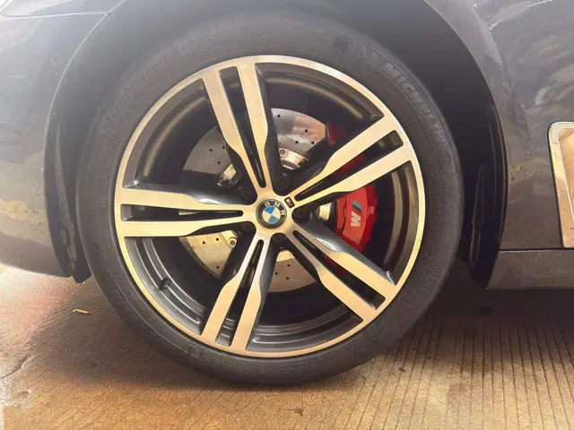 Red brake caliper visible behind a BMW alloy wheel after installation.