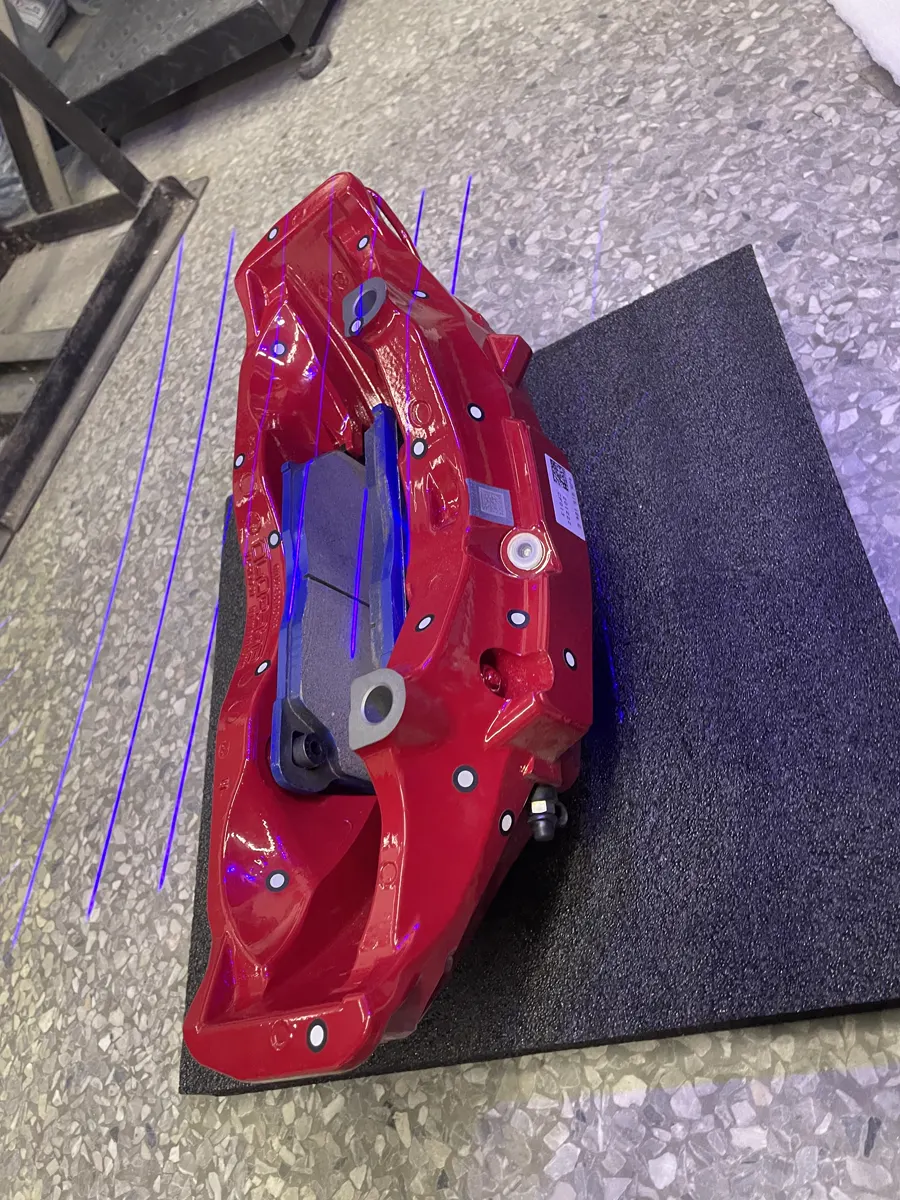 Red brake caliper and drilled rotor installed behind an alloy wheel for fitment inspection