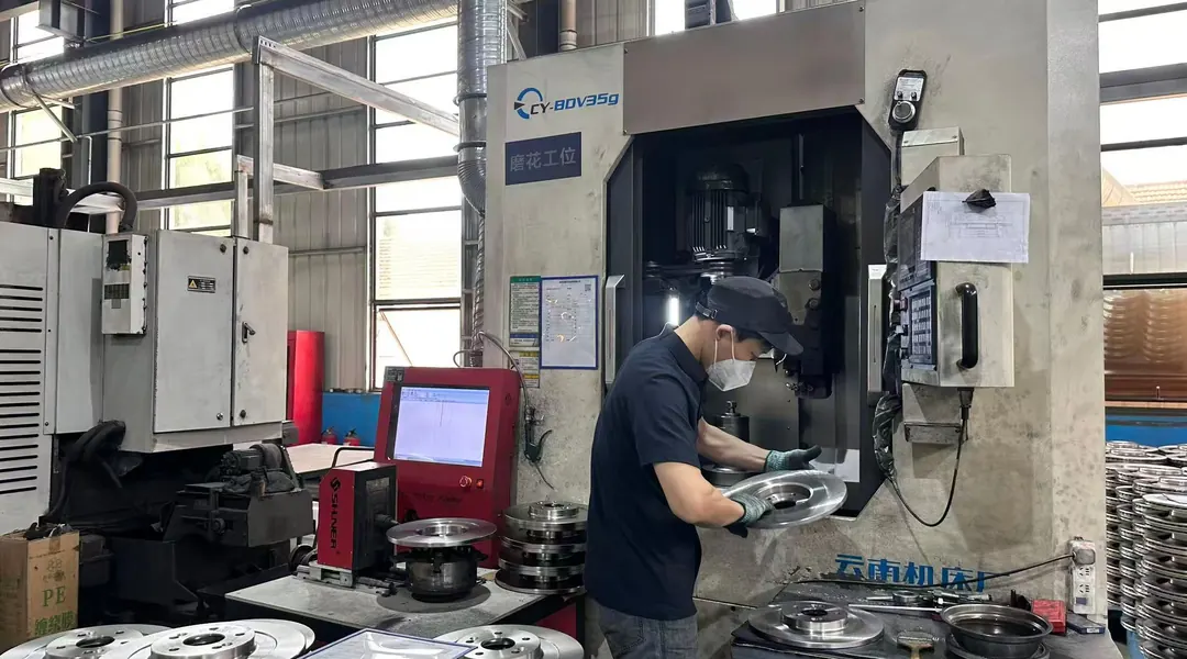 Operator running a CNC machining centre for brake components in the Guangzhou workshop