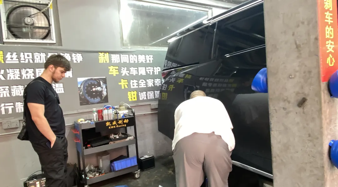 Technicians fitting a brake kit to a vehicle inside the workshop