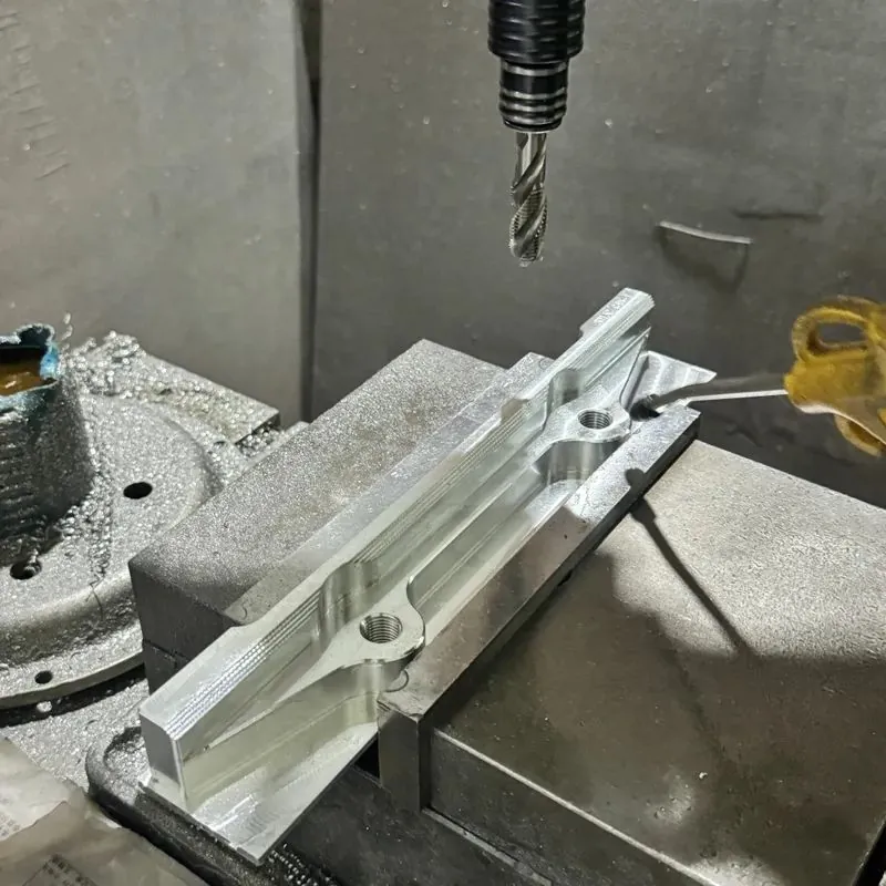 Caliper or bracket blank clamped on the CNC table during machining