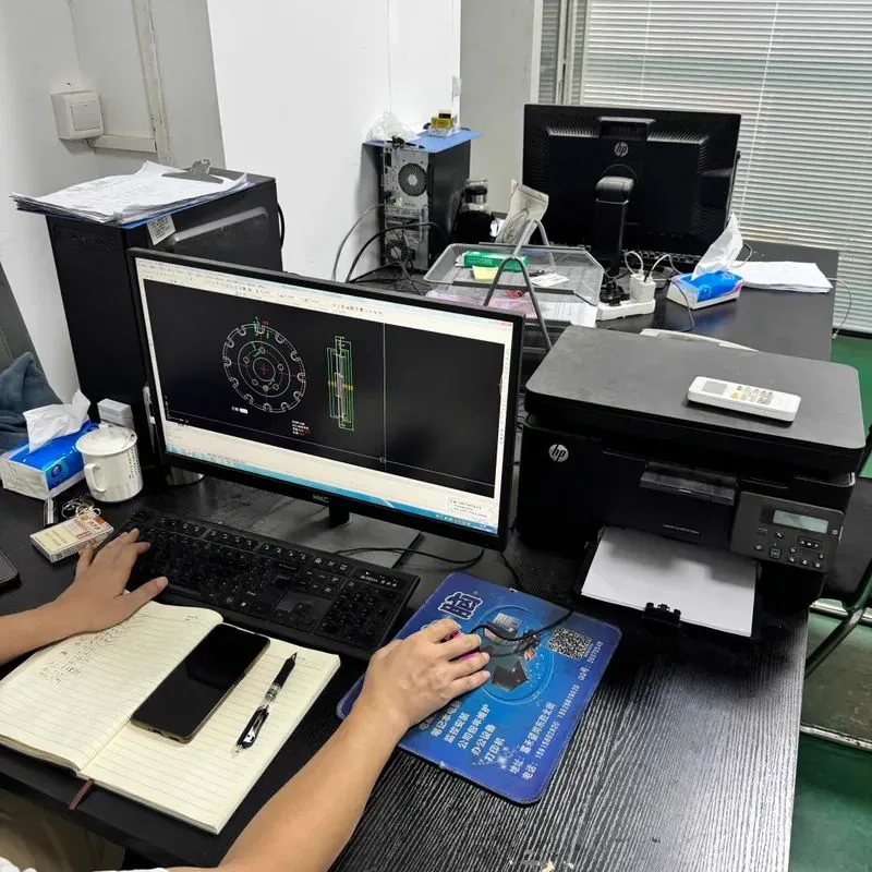 Technical support desk with a CAD screen, notes and printer