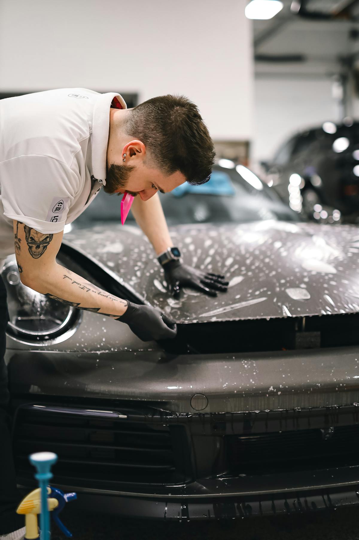 Workshop technician checking vehicle exterior parts before installation