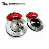 Pair of red front brake calipers with drilled rotors and adapter brackets arranged as a complete kit.