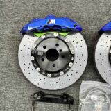 Close view of a GT6 six-piston front caliper, adapter bracket and rotor interface for BMW F30 fitment review.