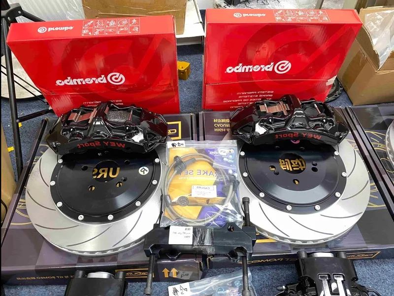BMW E60 brake caliper kit display with two black six-piston calipers, rotors, pads and hoses