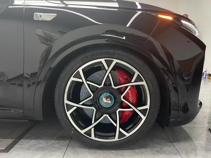 Akebono 10N front caliper and drilled rotor shown behind an installed alloy wheel