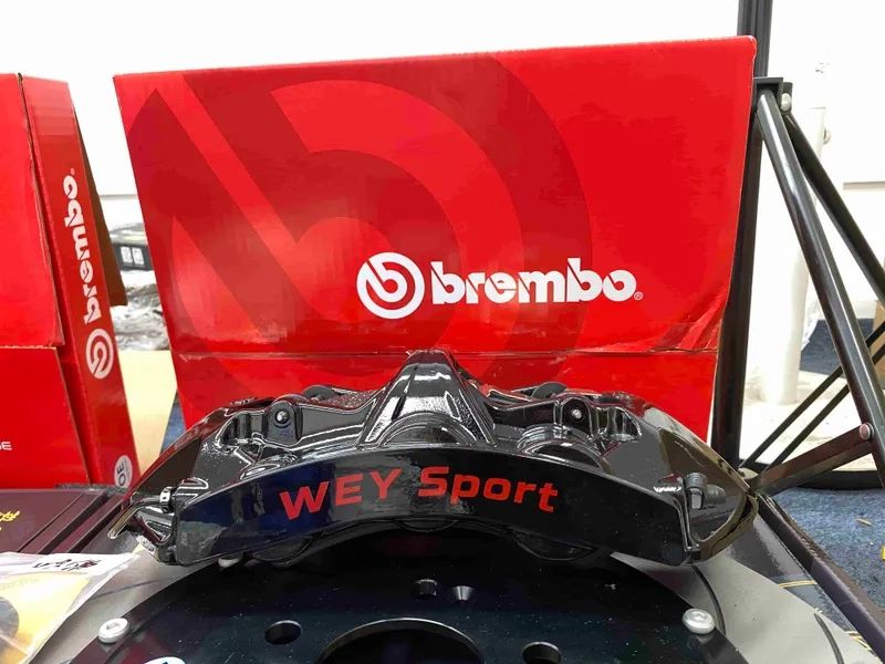 Black six-piston brake caliper detail with visible exterior finish and hardware