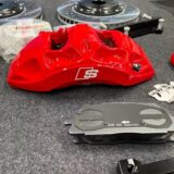Detail view of one caliper from the BMW X5 E70 Akebono 8N front big brake kit, with the piston bores and bleed screw visible