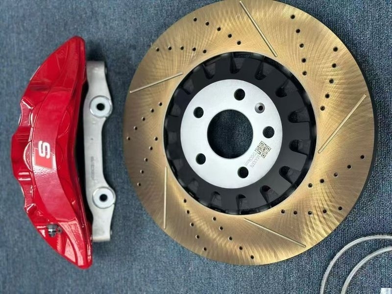 Brake kit detail reference showing a red caliper, adapter bracket, drilled and slotted rotor, and hose; not fitment evidence