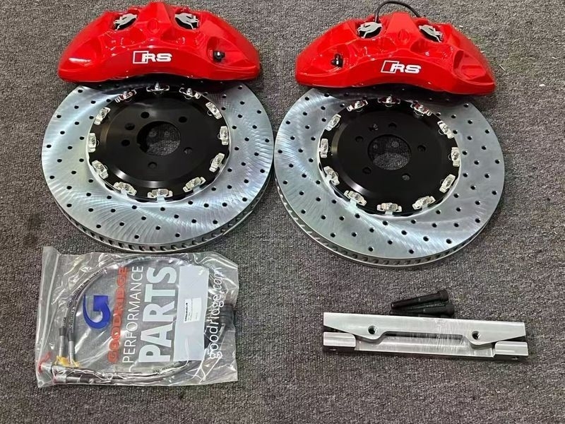 Brake kit detail reference showing two red calipers, drilled and slotted rotors, pads and adapter hardware; one caliper is marked R8; not fitment evidence